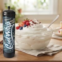 Glass bowl of fluffy whipped topping with strawberries, blueberries and chocolate shavings beside a berry sponge cake, Where to Buy Cool Whip